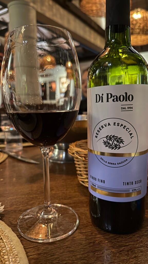 Garrafa de vinho com rótulo Di Paolo e taça servida no restaurante de Bento Gonçalves (RS)